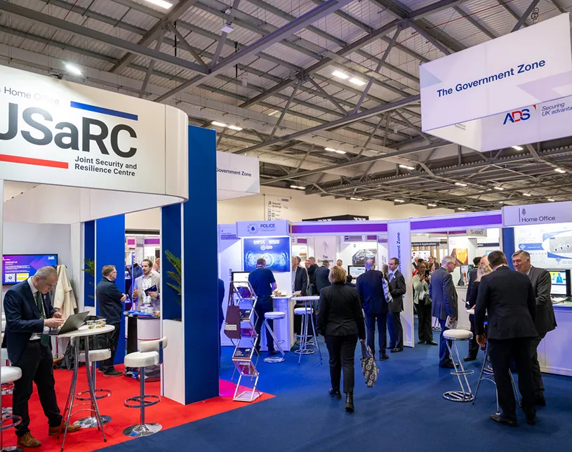 Visitors walk past the JSaRC stand in the Government Zone at Security & Policing.