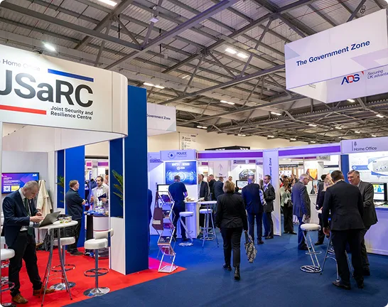 Visitors walk past the JSaRC stand in the Government Zone at Security & Policing.