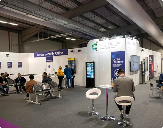 Tables and chairs beside exhibition displays in the Immersive Experience area.
